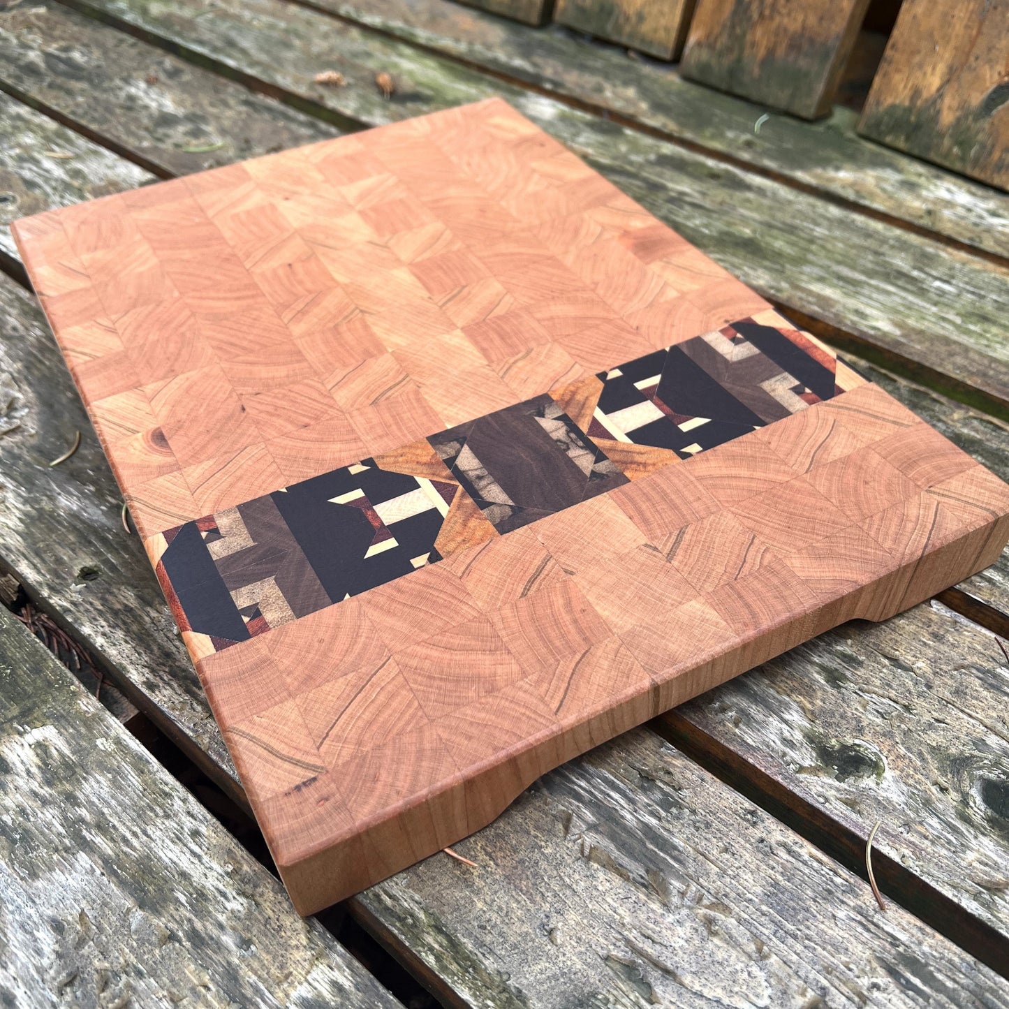 Wooden cutting board with a wavy edge on a wooden surface