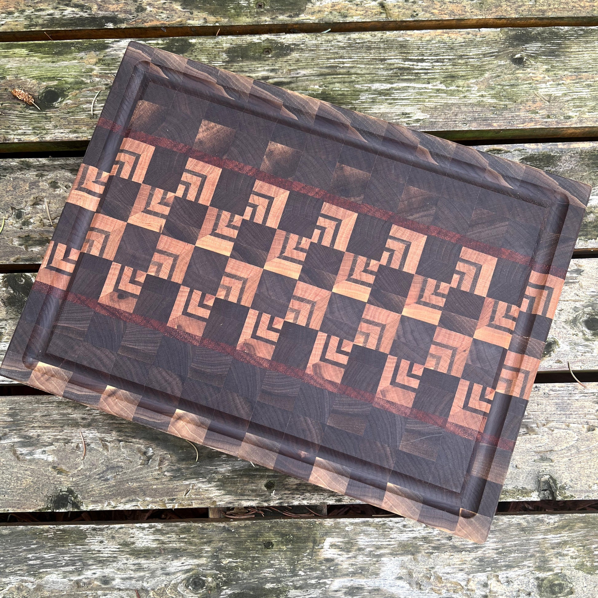 Wooden cutting board with geometric pattern on a wooden surface