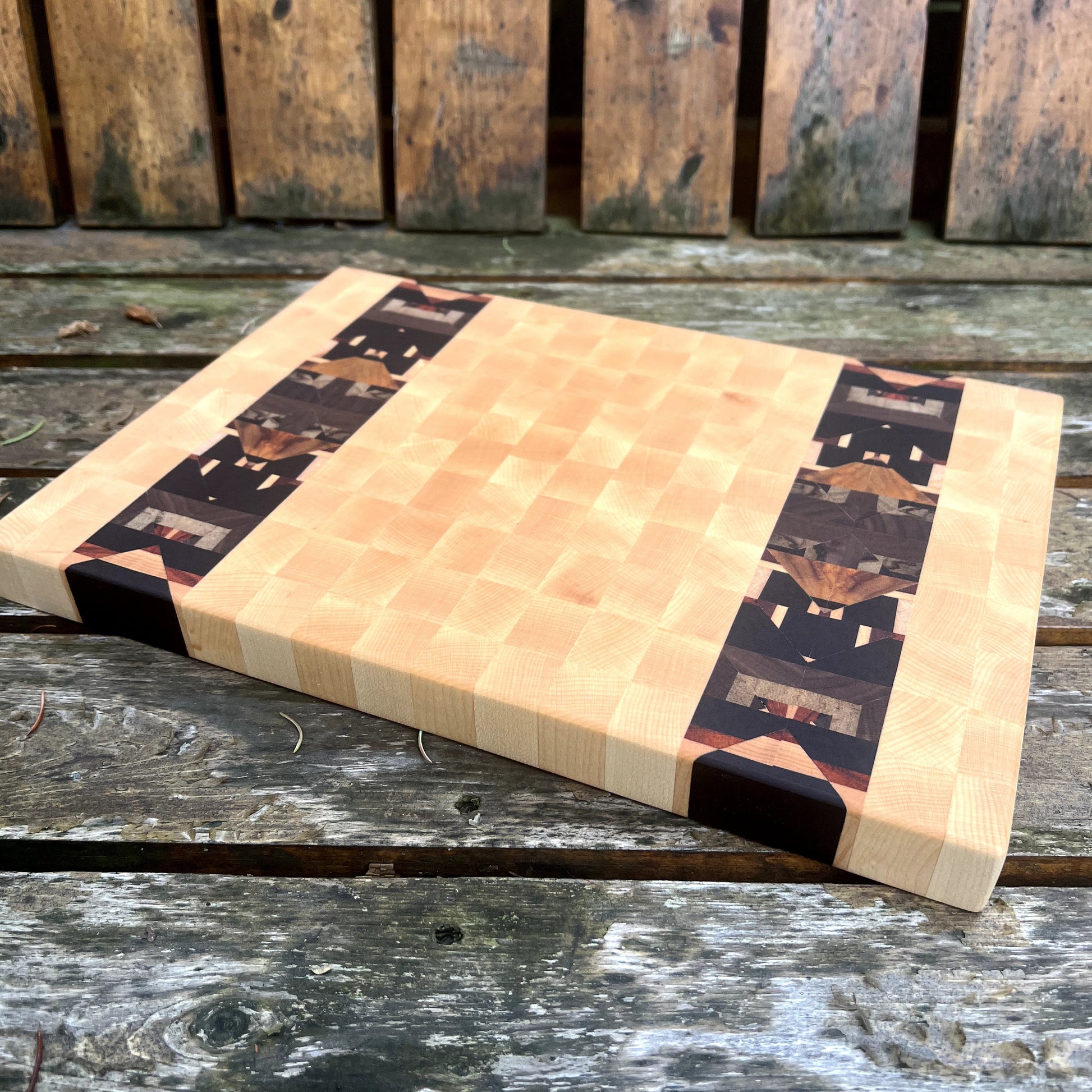 Butcher block cutting board with black and white pattern on a wooden surface