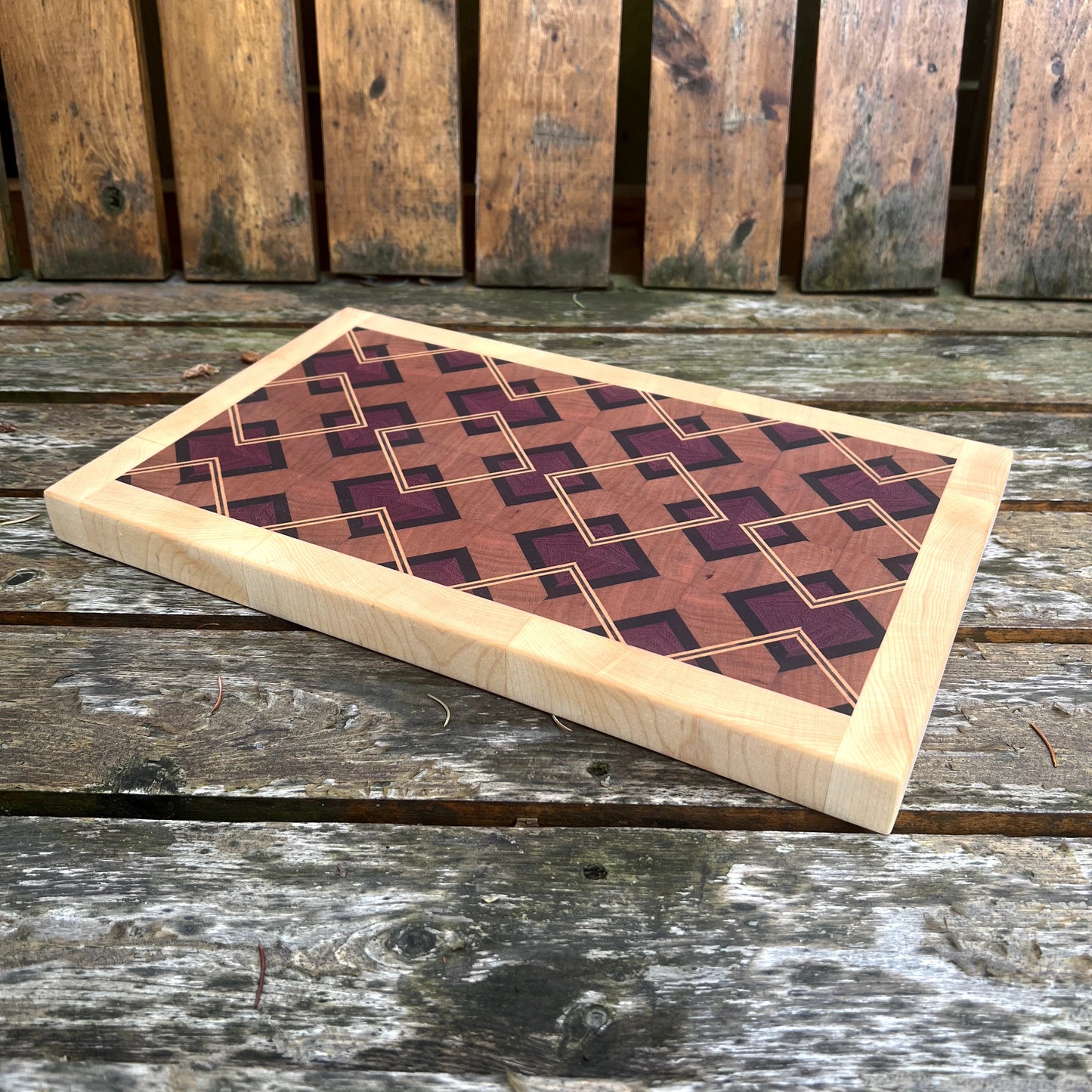 Wooden cutting board with geometric pattern on a wooden surface
