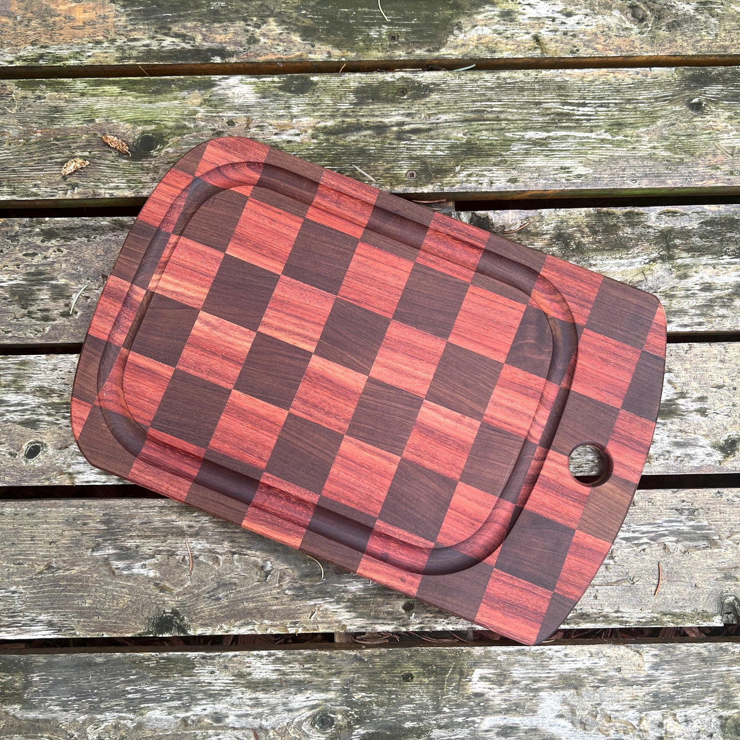Red and brown checkered pouch on a wooden surface