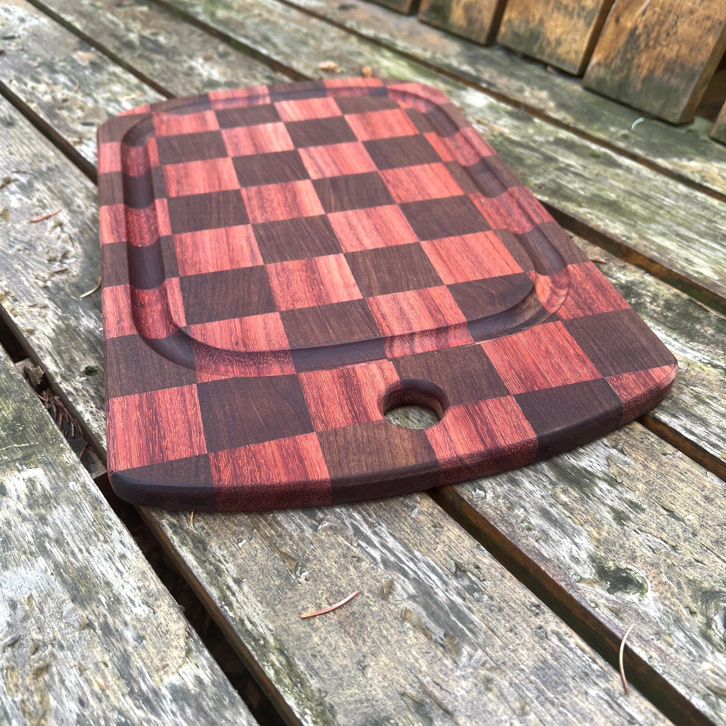 Checkered wooden cutting board on a rustic wooden surface