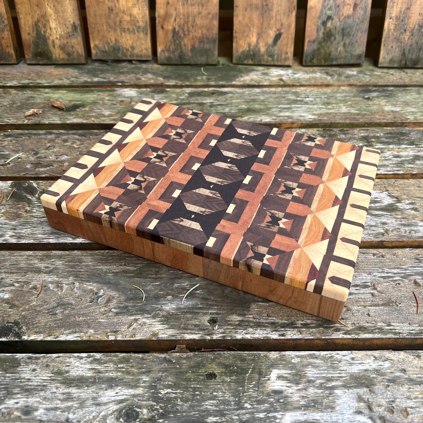 Wooden cutting board with geometric pattern on a wooden surface