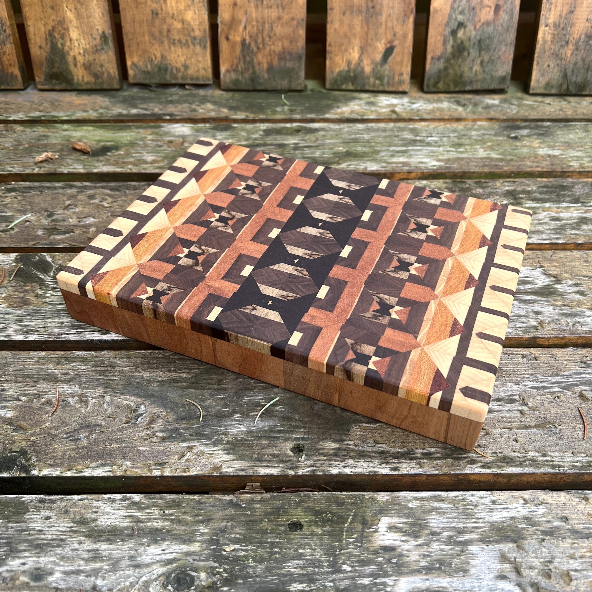 Wooden cutting board with geometric pattern on a wooden surface
