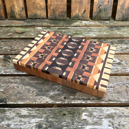 Wooden cutting board with geometric pattern on a wooden surface