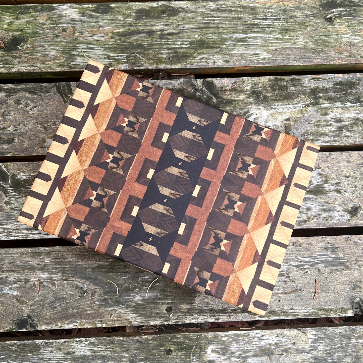 Wooden cutting board with geometric pattern on a wooden surface