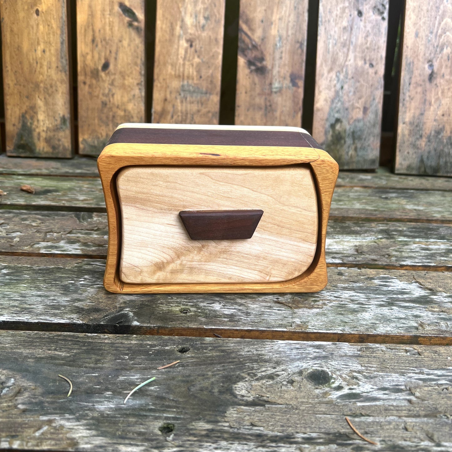 Wooden box with a handle on a wooden surface