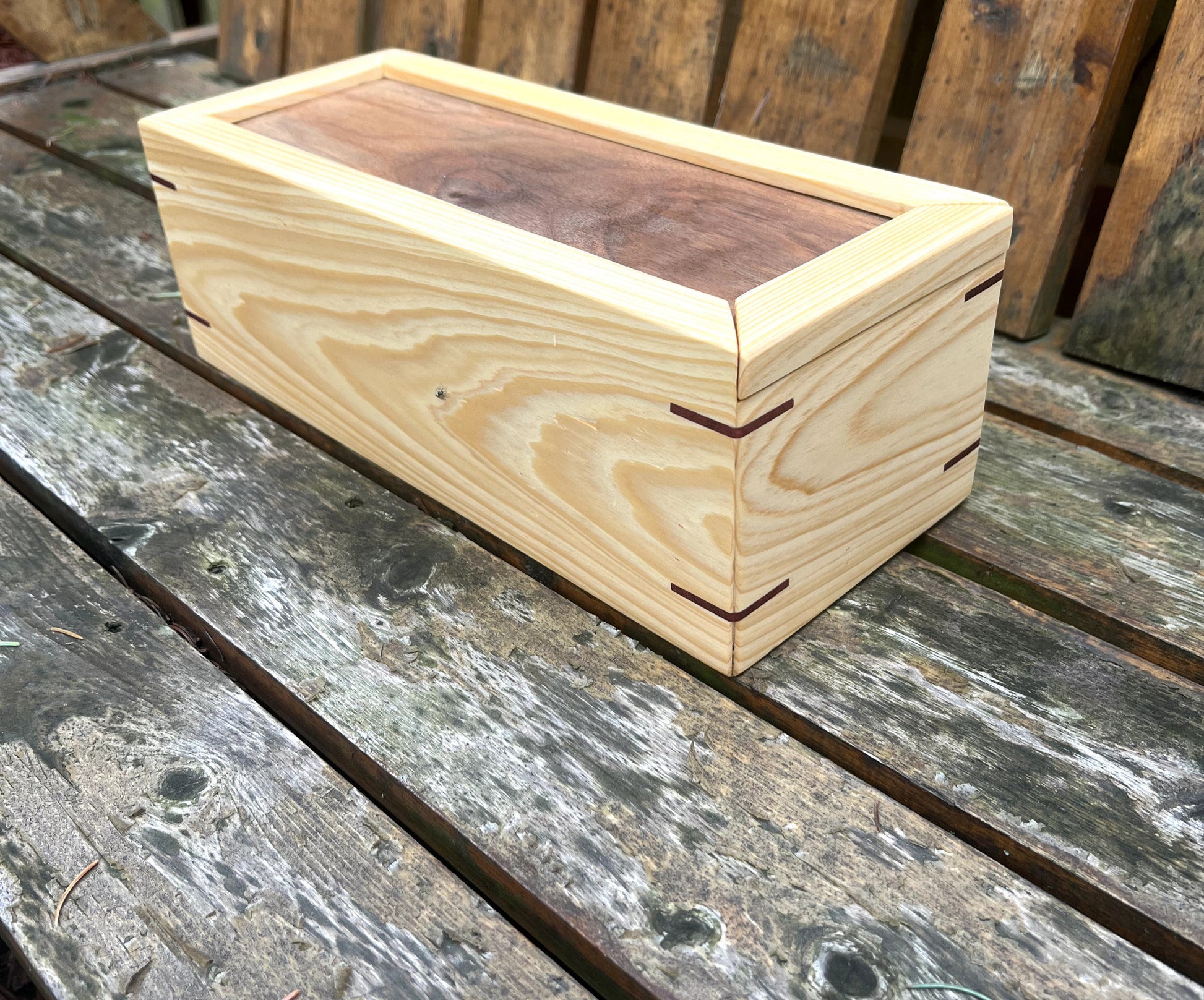 Wooden box with a sliding lid on a wooden surface