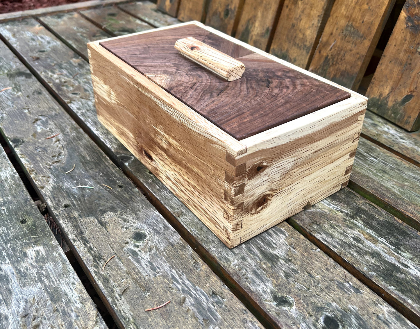 Wooden box with a dark brown lid on a wooden surface
