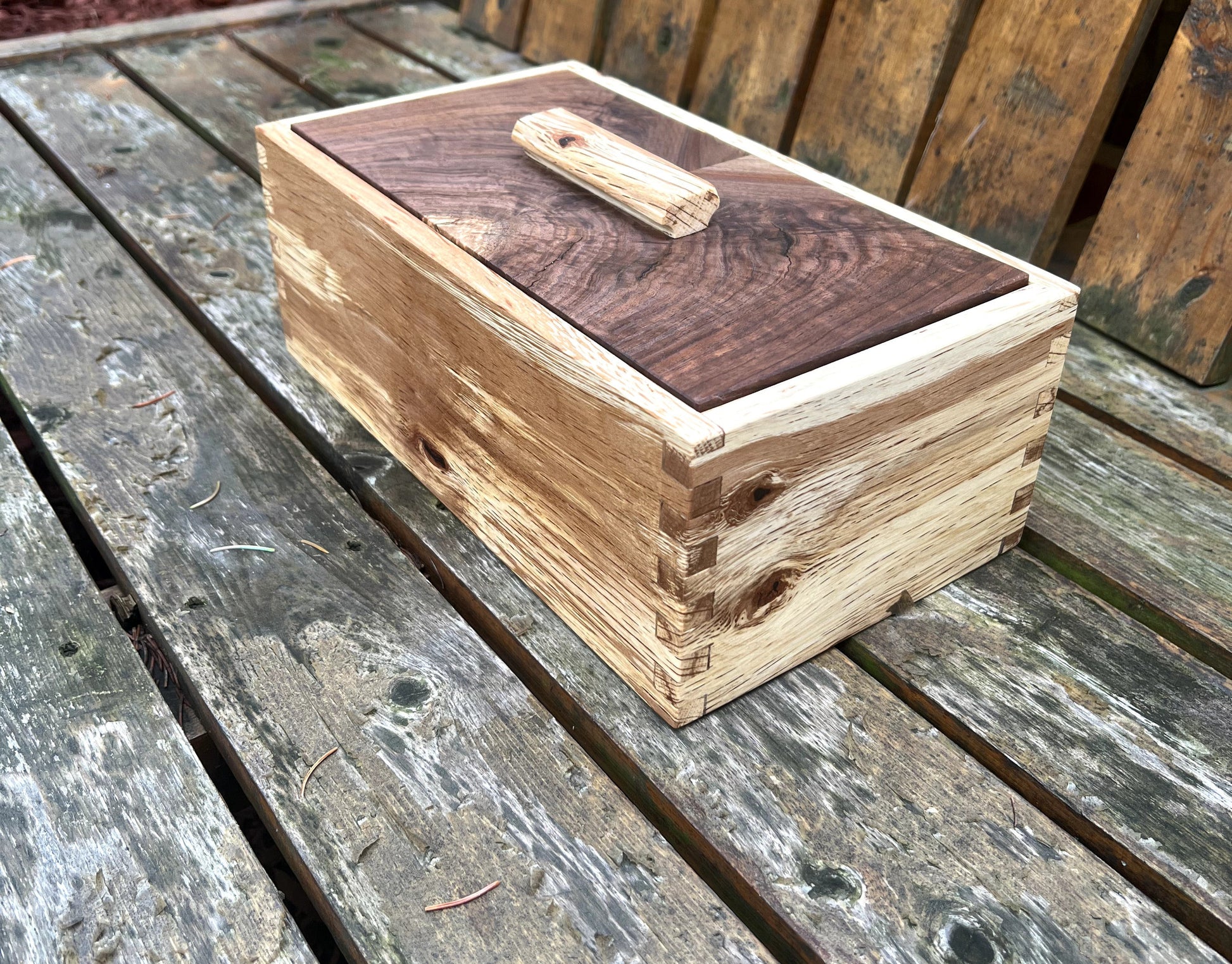 Wooden box with a dark brown lid on a wooden surface