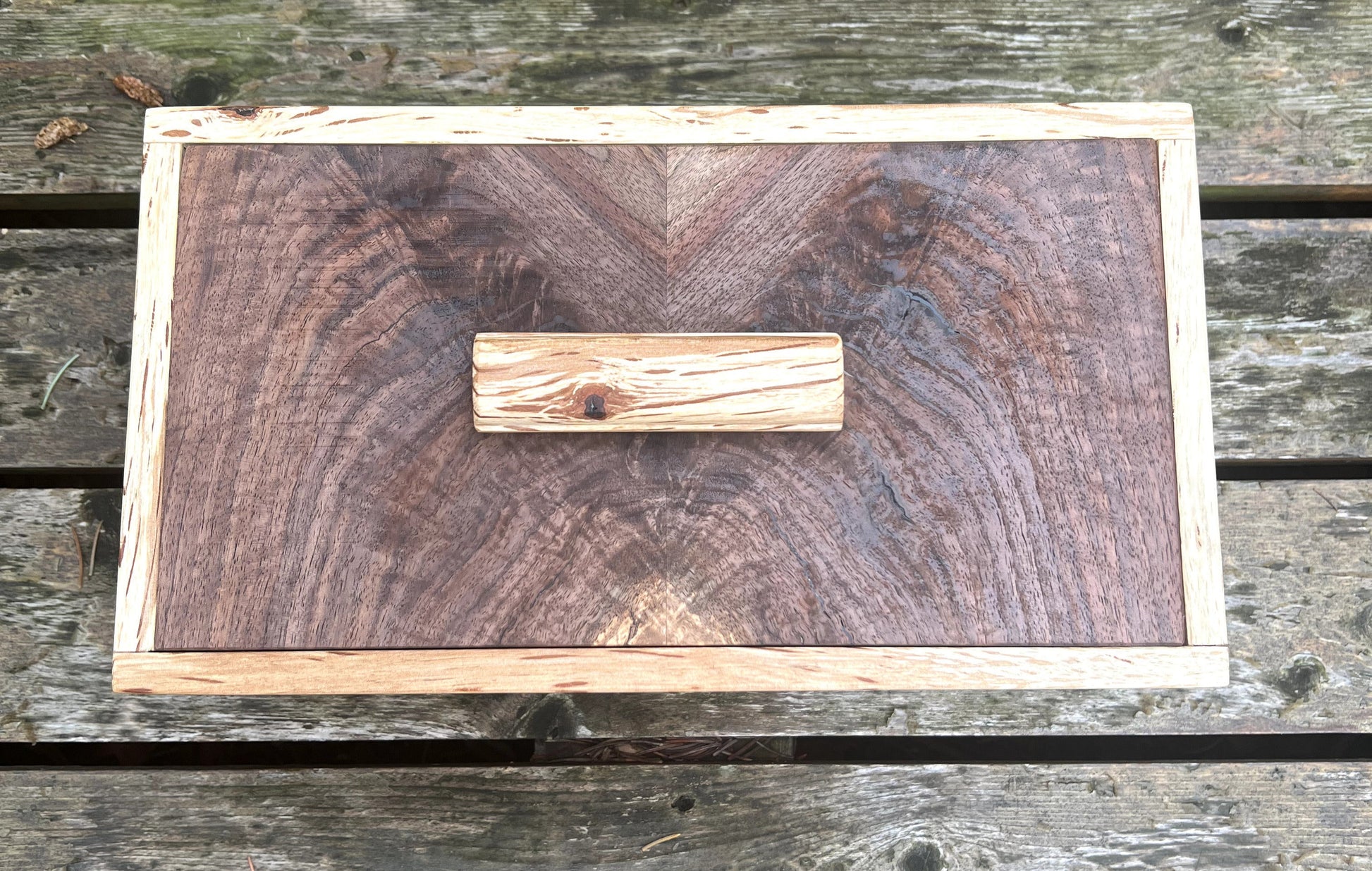 Wooden cutting board with a visible brand logo on a wooden surface