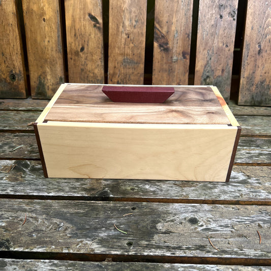 Wooden box with a walnut lid on a wooden surface