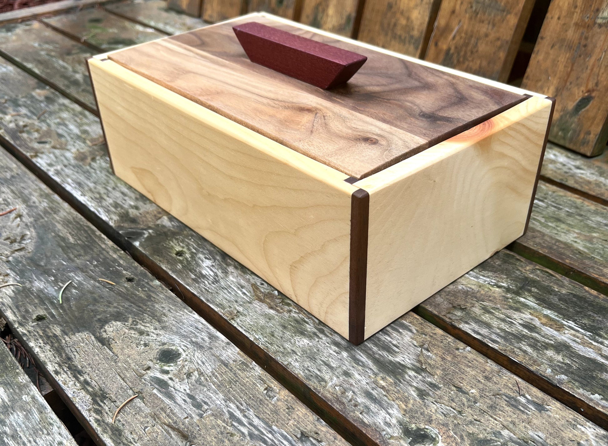 Wooden box with a dark wood top on a wooden surface