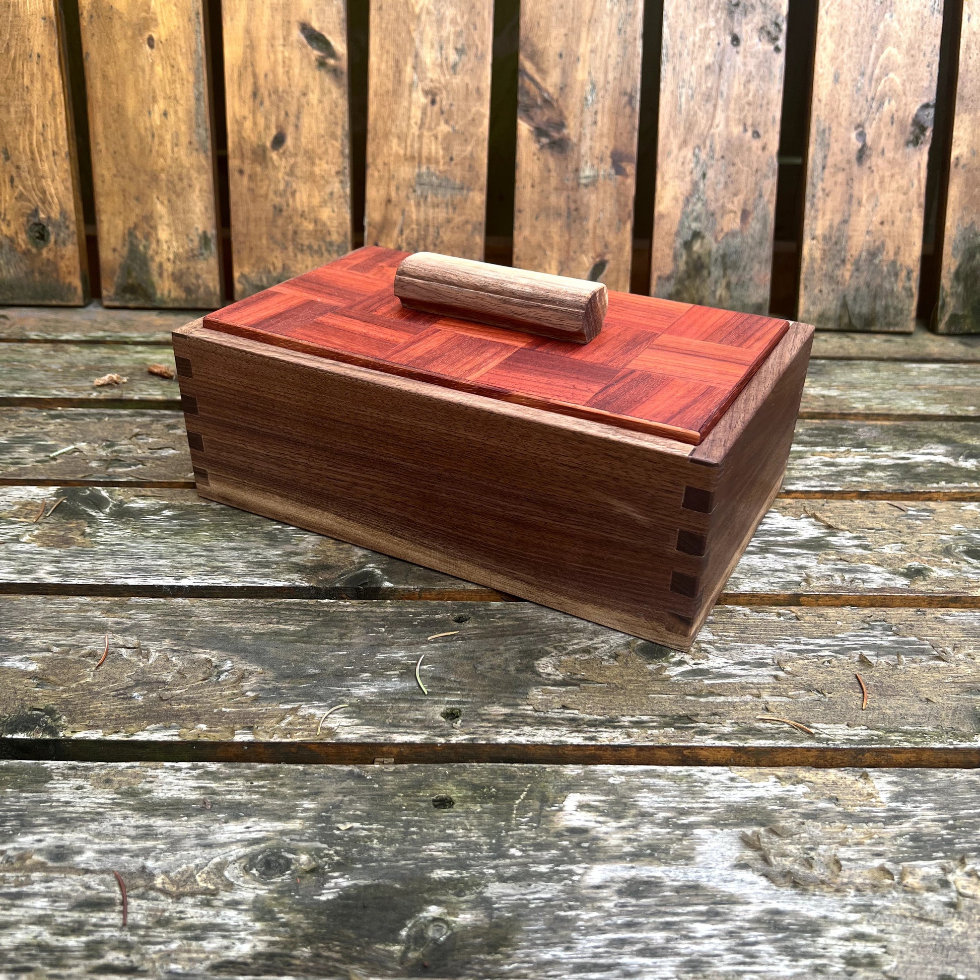 Wooden box with a red top on a wooden surface