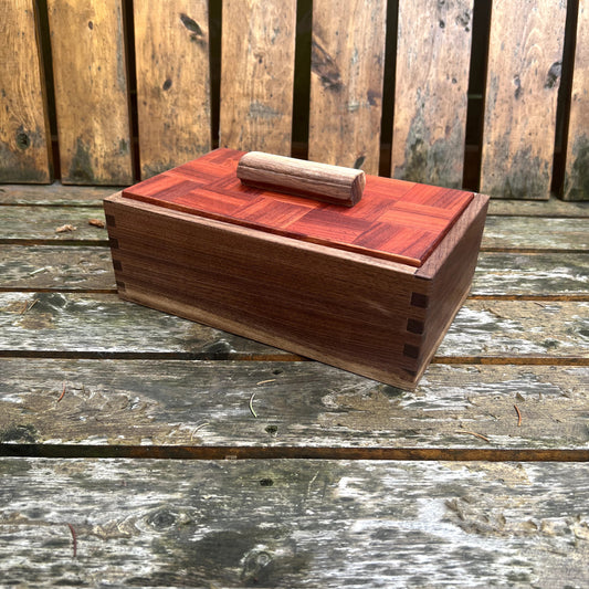 Wooden box with a red top on a wooden surface