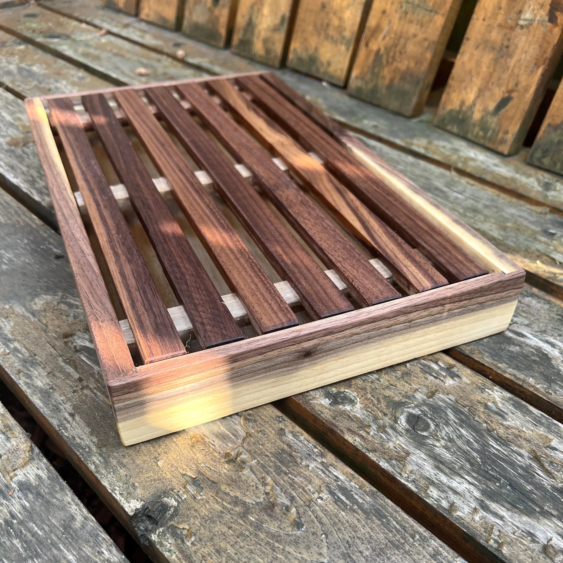 Wooden cutting board with a slatted design on a wooden surface