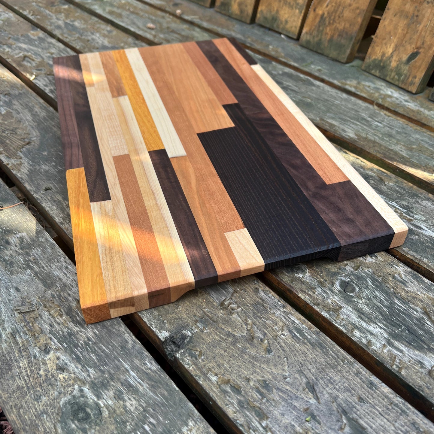 Wooden cutting board with multicolored pattern on a wooden surface