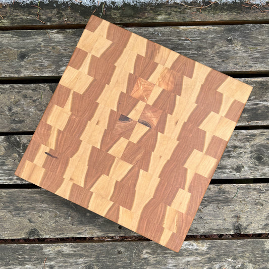 “The Ember cutting board — handcrafted end-grain cherry butcher block with mosaic pattern, 12x12x1.75 inches.”