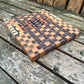 Wooden cutting board with checkered pattern on a wooden surface