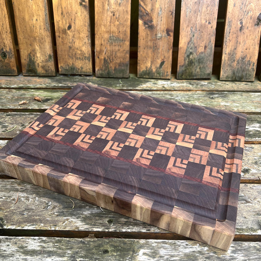 Wooden cutting board with geometric pattern on a wooden surface