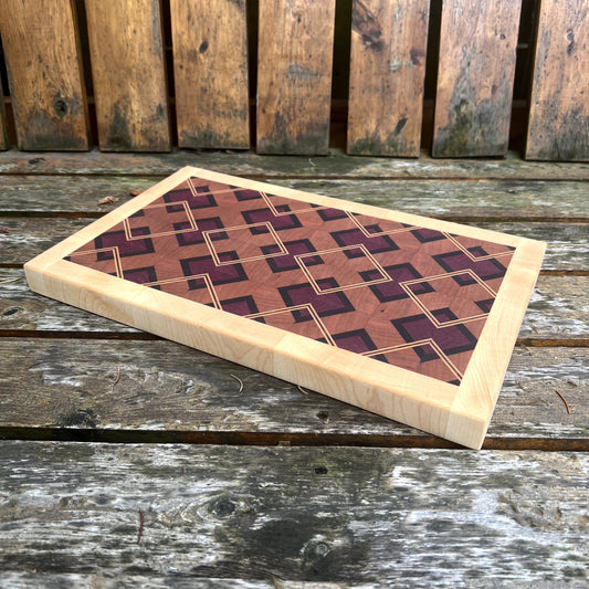 Wooden cutting board with geometric pattern on a wooden surface