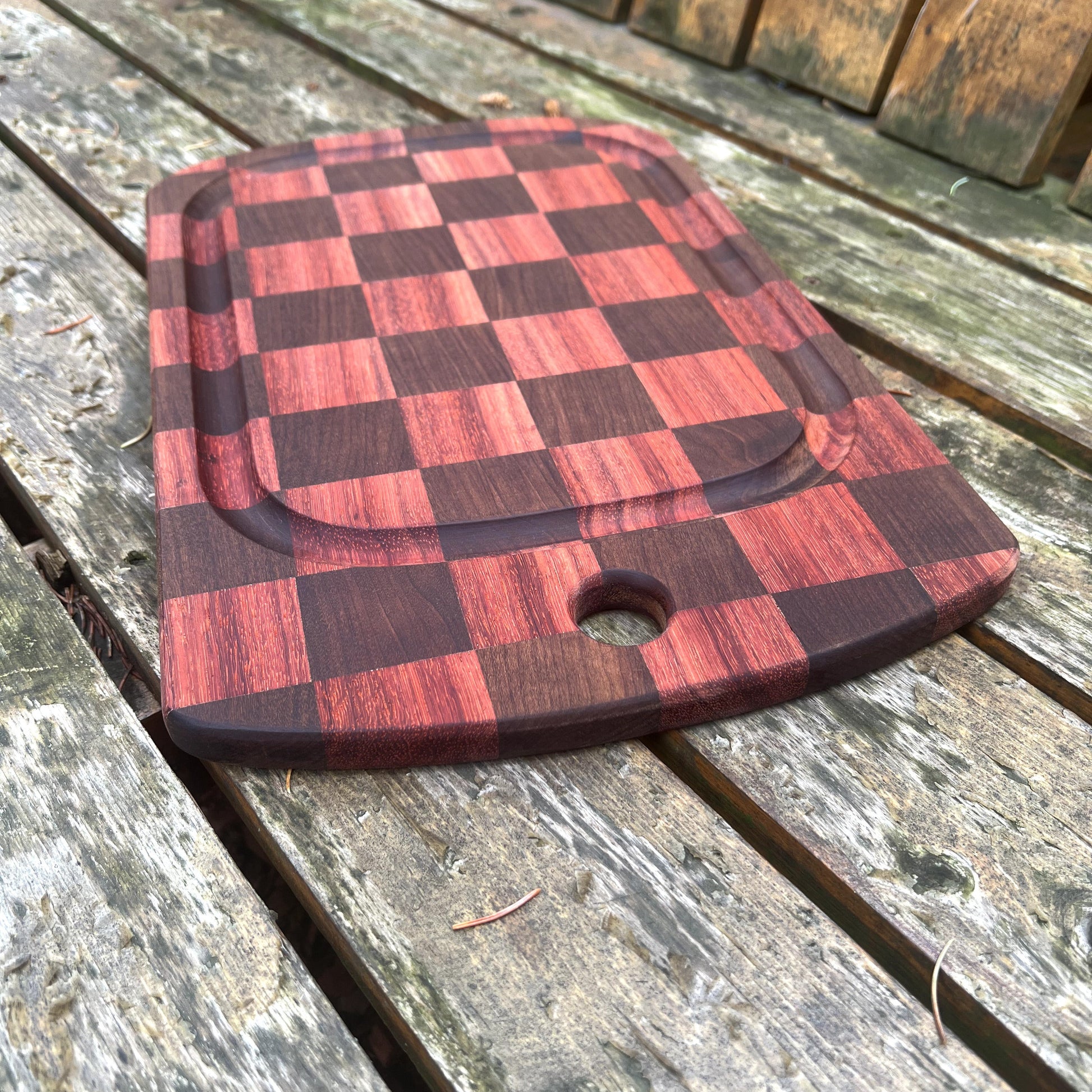 Checkered wooden cutting board on a rustic wooden surface