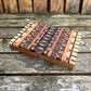 Wooden cutting board with geometric pattern on a wooden surface