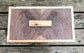 Wooden cutting board with a visible brand logo on a wooden surface