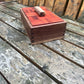 Wooden jewelry box with red top on a wooden surface