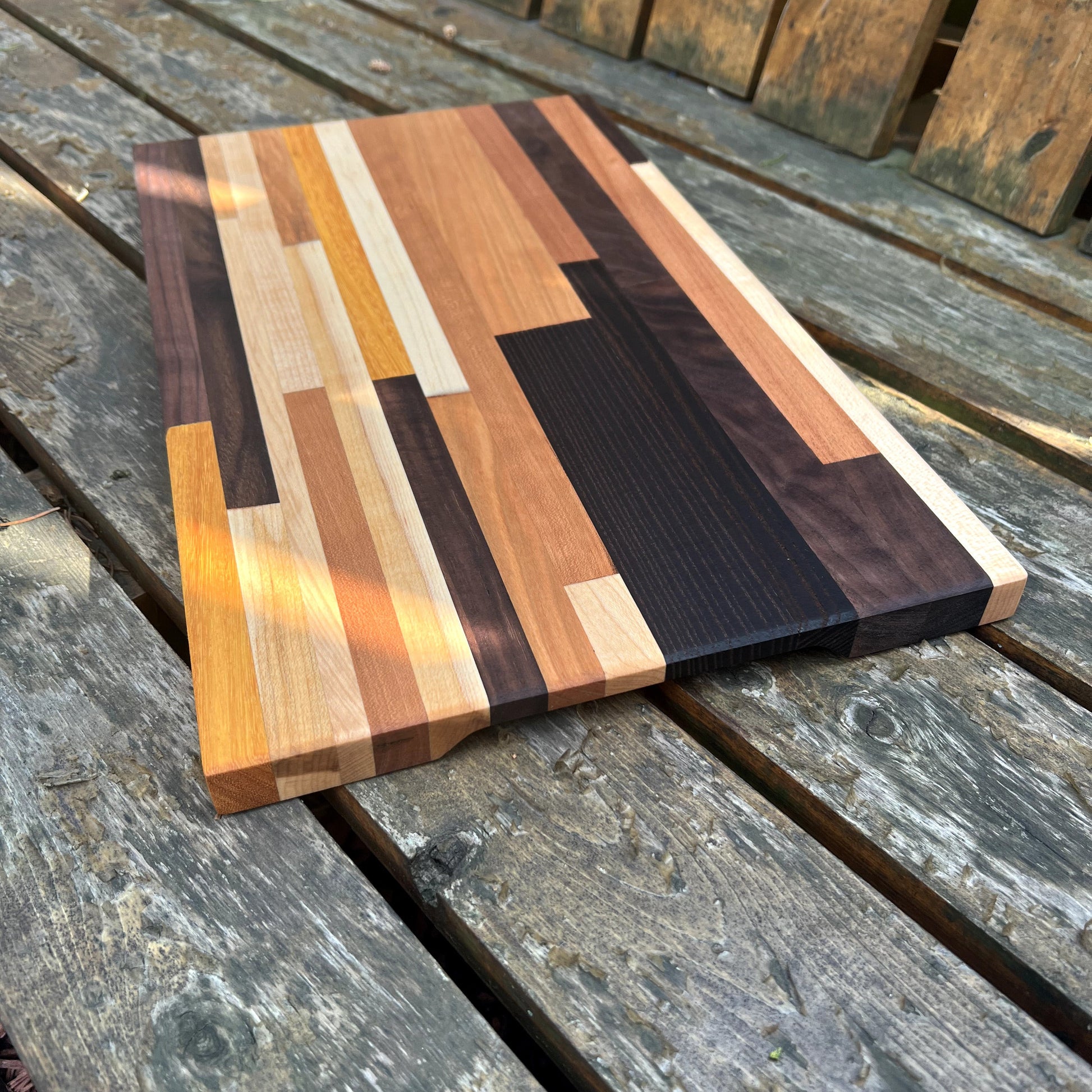 Wooden cutting board with multicolored pattern on a wooden surface